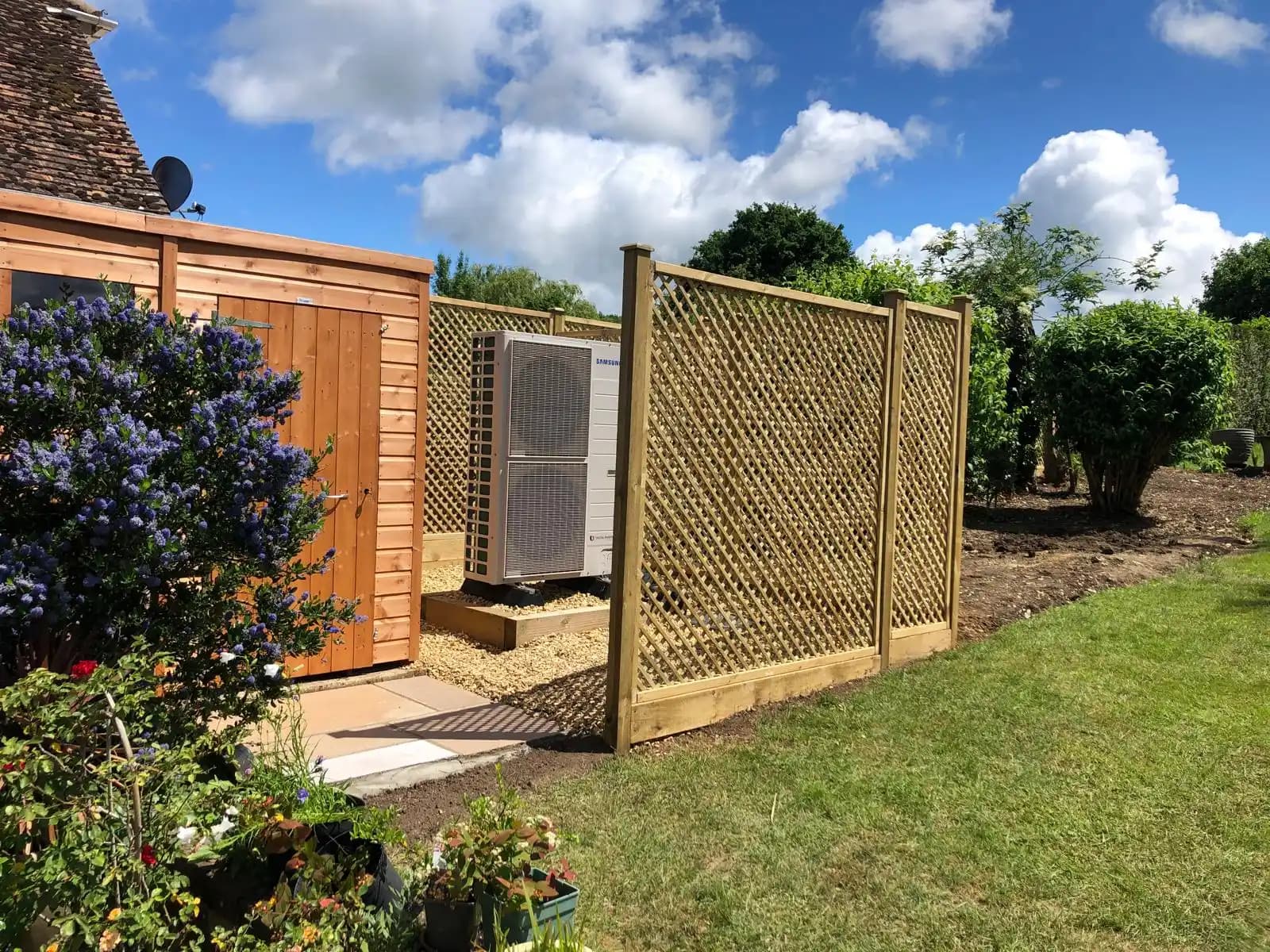 Garden trellis screening panel beside a patio under blue sky